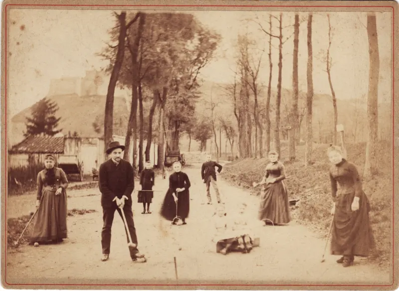 Photographie ancienne : une famille réunie sur une allée bordée d'arbres