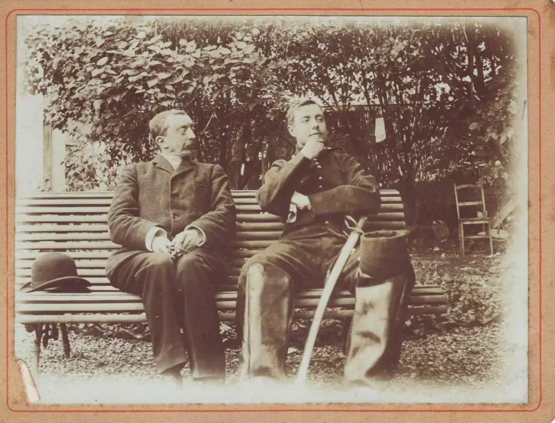 Photographie ancienne : deux hommes assis sur un banc de jardin